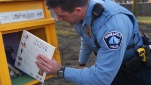 Minneapolis Police Officers stock and care for the books in the Little Free Libraries.