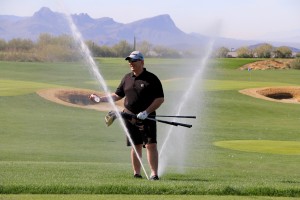 Paul HIllen found a special spot to escape the sprinklers on the golf practice tee.